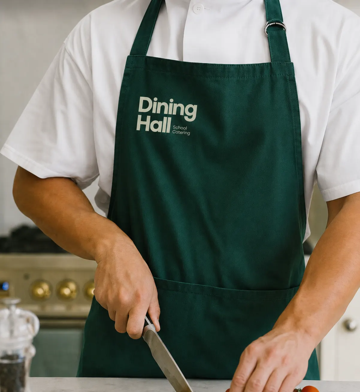 Chef de Dining Hall con delantal verde de marca trabajando en cocina